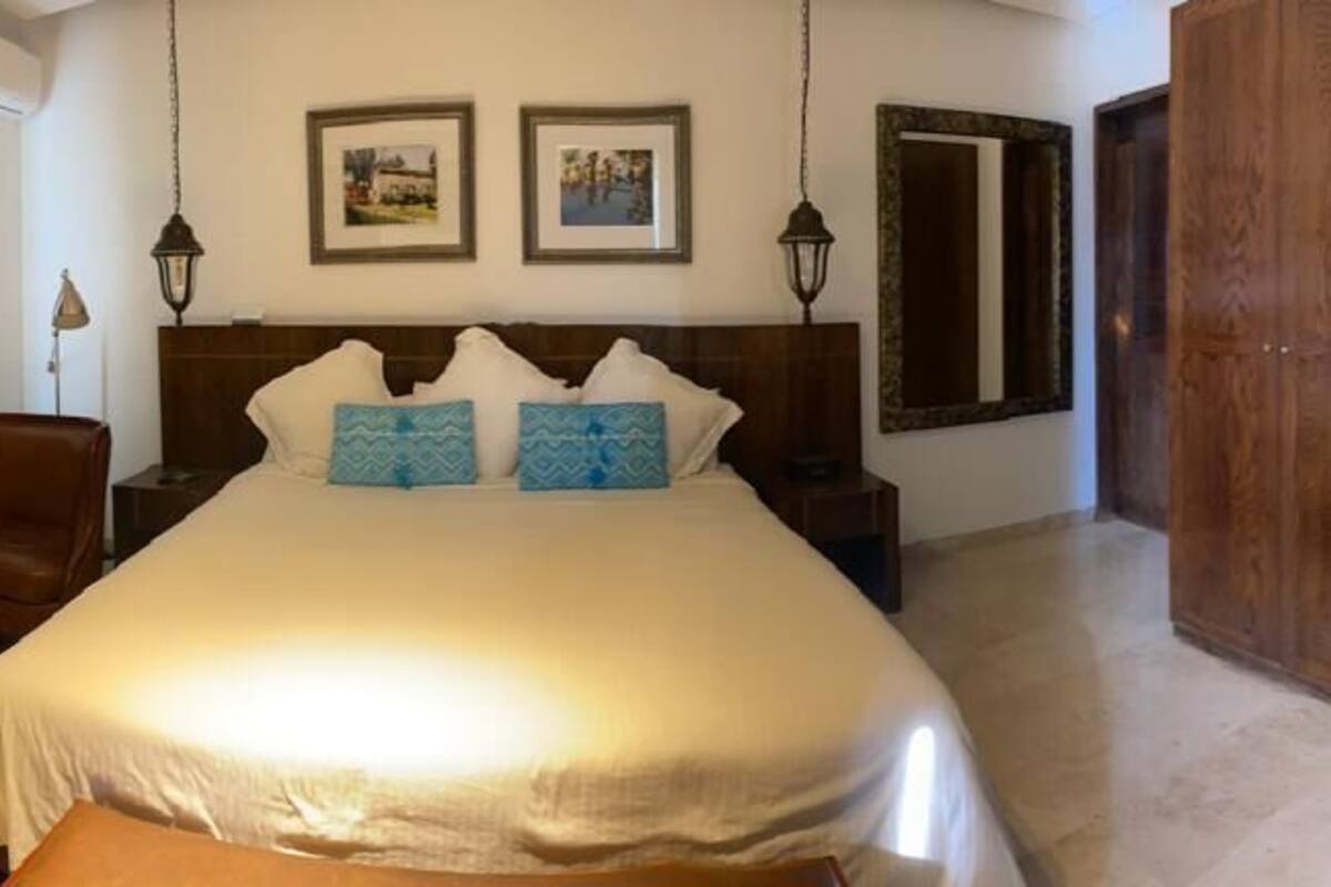Un dormitorio con una cama grande, un armario de madera, un escritorio y una silla.