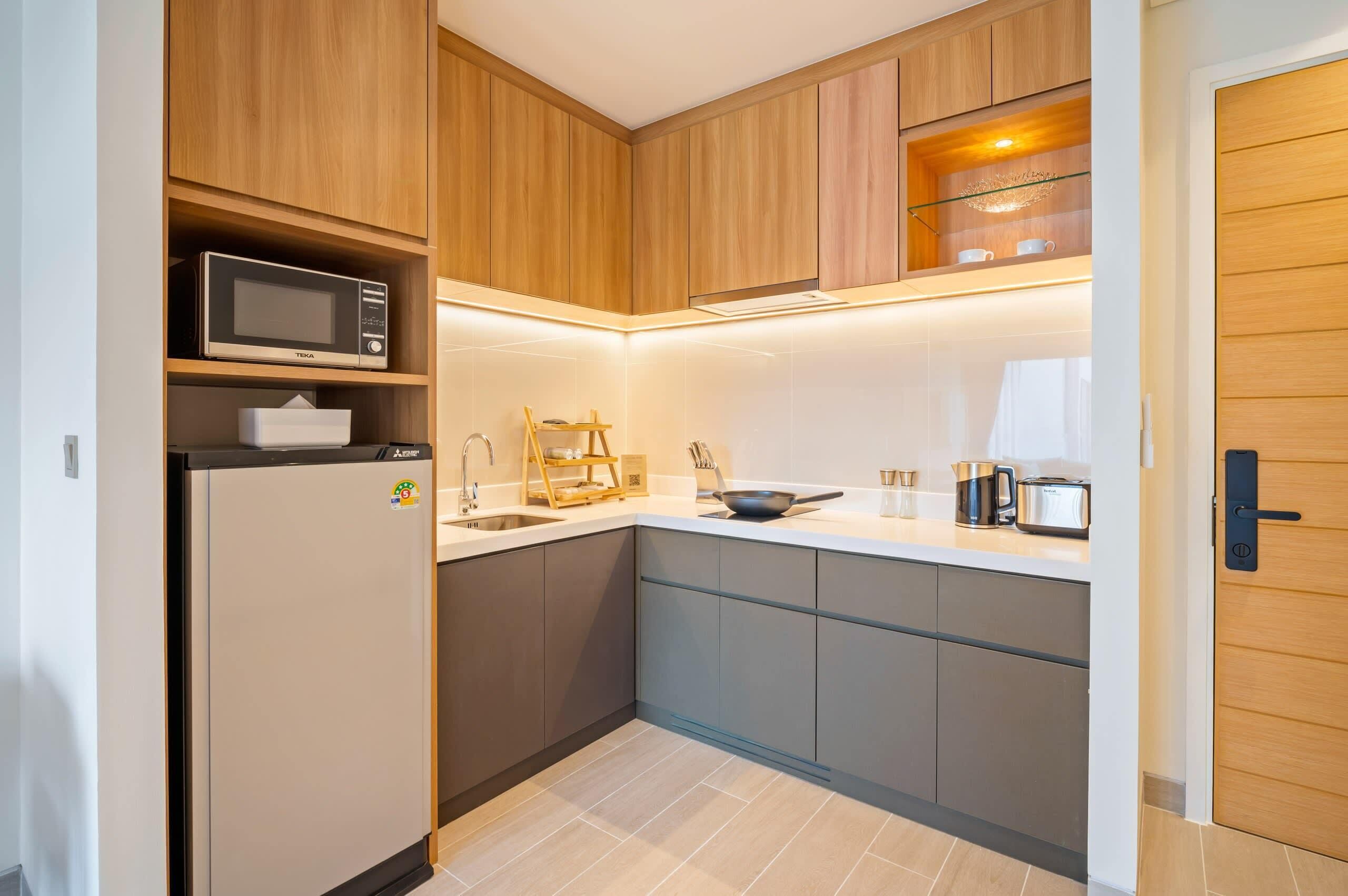 A modern kitchen with wooden cabinets, a built-in microwave, and a stainless steel sink.