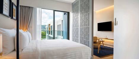 A modern hotel room with a large bed, a desk, a chair, a TV, and a balcony with a view of the city.