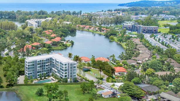 Een resort met een centraal meer, omringd door weelderige begroeiing en woongebouwen.