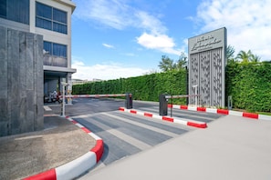 A gated entrance to a hotel with a modern building and a sign reading "Laguna Lakeside Residence".