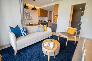 Ein modernes Wohnzimmer mit einer Couch, einem runden Couchtisch und einem Essbereich mit einem Stuhl.