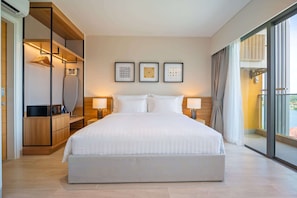A modern hotel room with a large bed, bedside lamps, a wardrobe, and a balcony with a view.