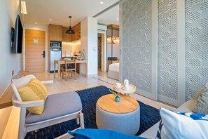 Un salon moderne avec un canapé, une table basse et un téléviseur fixé au mur.