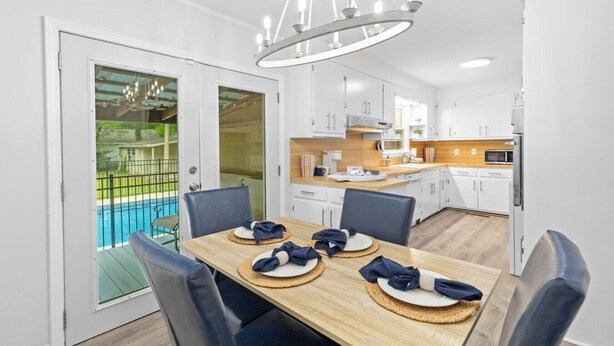 A modern kitchen with white cabinets, a wooden countertop, and a built-in oven. - 3BR Pool Home | Free Parking | Near Airport + DT (North Charleston)