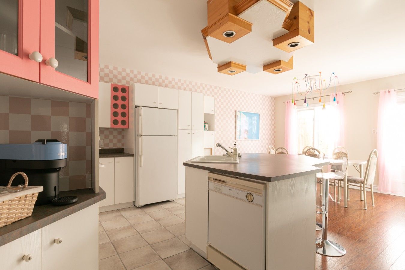 A kitchen with a central island, a refrigerator, and a sink.