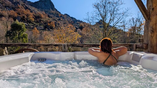 Eine Person entspannt sich in einer Hot Tub mit einer Berglandschaft im Hintergrund.