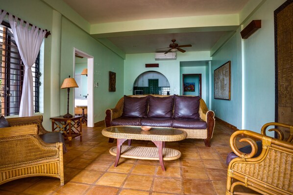 Relax in a cozy living room with a comfortable sofa, wicker coffee table, and armchairs.