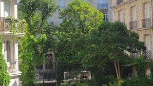 A courtyard with a pathway, surrounded by multi-story buildings with balconies and windows. - Paris Chic Trocadero Private apartment in Passy 500 meters from the Eiffel Tower  (Paris)