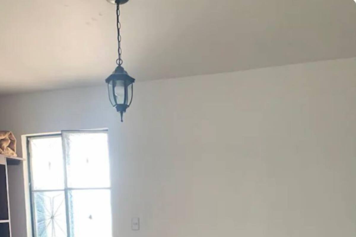 Une chambre avec deux lits, une fenêtre, une porte et une petite table de chevet.