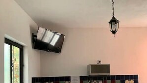 Une cuisine équipée d’un téléviseur fixé au mur, d’un four à micro-ondes et d’un luminaire suspendu.
