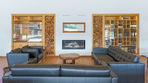 A modern living room with a sectional sofa, a coffee table, a fireplace, and a wine cellar. - Holiday Home 'Clarinha' with Mountain View, Wi-Fi and Air Conditioning (Odemira)