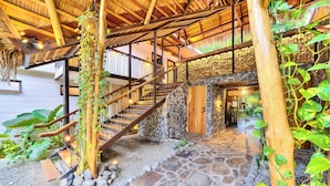 Una escalera de madera con piso de piedra que conduce a una puerta de madera.