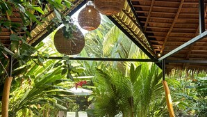 Un espacio al aire libre cubierto con muebles de madera y plantas grandes.