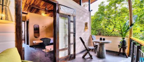 A spacious patio with a dining table, chairs, and a wicker sofa.