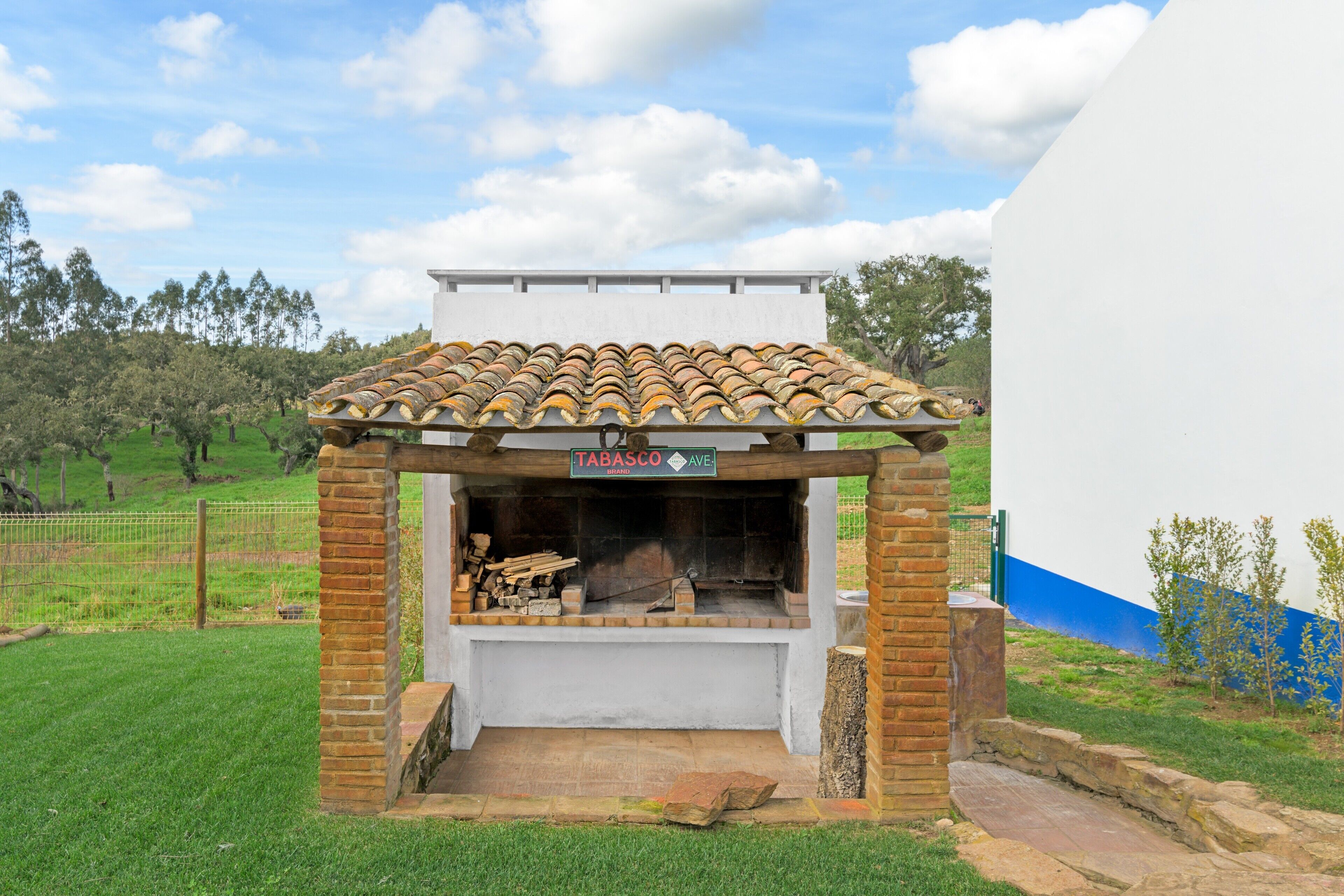 A brick-built outdoor barbecue area with a tiled roof, labeled 'TABASCO AVE.'
