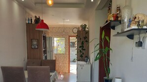 A modern living room with a dining area, featuring a sofa, chairs, a coffee table, and a hanging light fixture. - Casa Harmonia do Litoral - Florianopolis (Florianópolis)