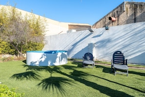 A pool, two chairs, and a wall with a drainage pipe. - Holiday Home 'Costa Daurada' with Private Terrace, Wi-Fi and Air Conditioning (Tarragona)