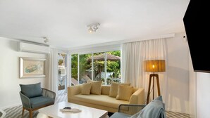 Un salon moderne comprenant un canapé, des fauteuils, une table basse et un lampadaire.