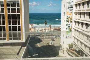 A view of a coastal street with buildings, a beach, and the ocean. - Domus Tlv (Tel Aviv)
