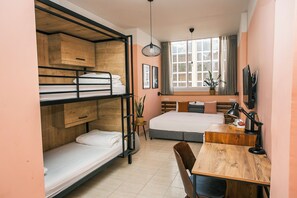 A compact room with bunk beds, a desk, and a window with curtains. - Domus Tlv (Tel Aviv)