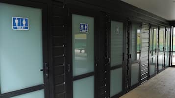 A row of closed restroom doors with blue signage indicating gender-specific facilities.