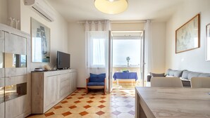 Eine moderne Küche mit Essbereich, einem Fernseher und Blick ins Freie.