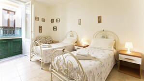 Une chambre avec deux lits, un balcon et vue sur la mer.