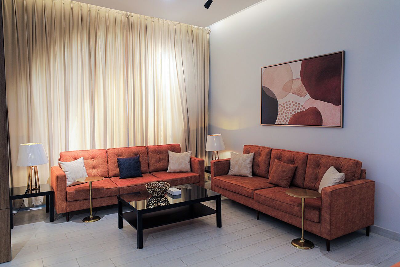 A modern living room with two sofas, a coffee table, and two lamps.