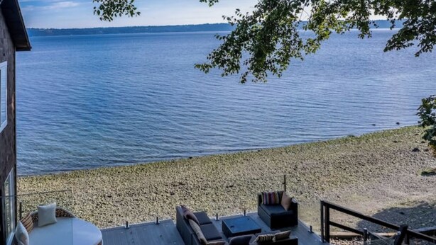 A deck with outdoor seating, a hammock, and a view of the water. - Vashon Modern Waterfront Retreat+Private Beach+BBQ+Firepit (Vashon)