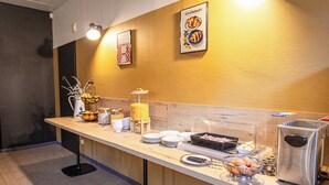 A buffet counter with various food items and a coffee machine. - Côté Lac Hostel (Neuvecelle)