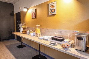 A buffet counter with various food items and a coffee machine. - Côté Lac Hostel (Neuvecelle)