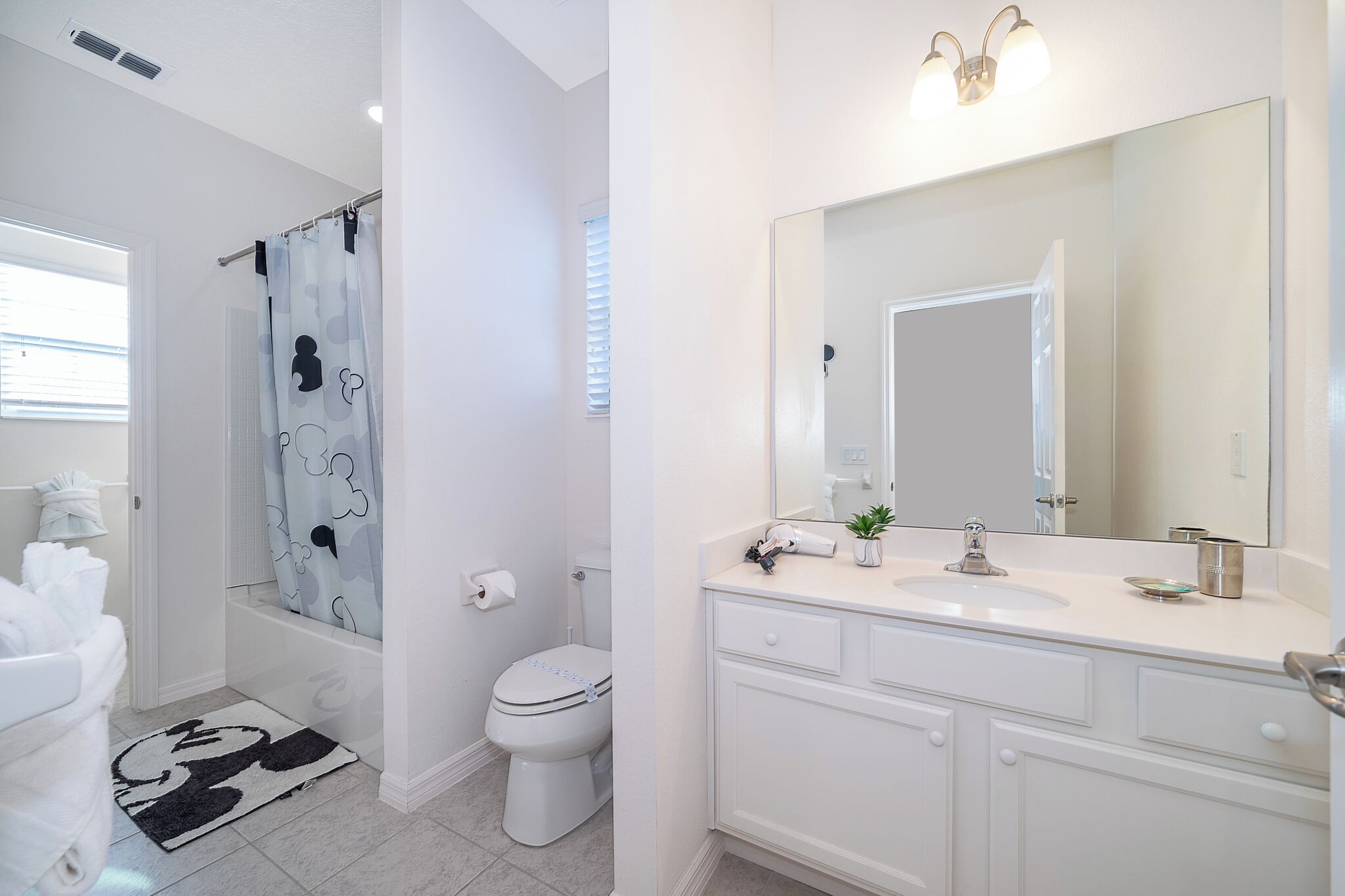 Ein Badezimmer mit Dusche, Toilette, Waschbecken und Spiegel.
