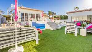 A pool area with artificial grass, lounge chairs, and a staircase leading to a second-floor balcony. - Beautiful home in Rojales (Rojales)