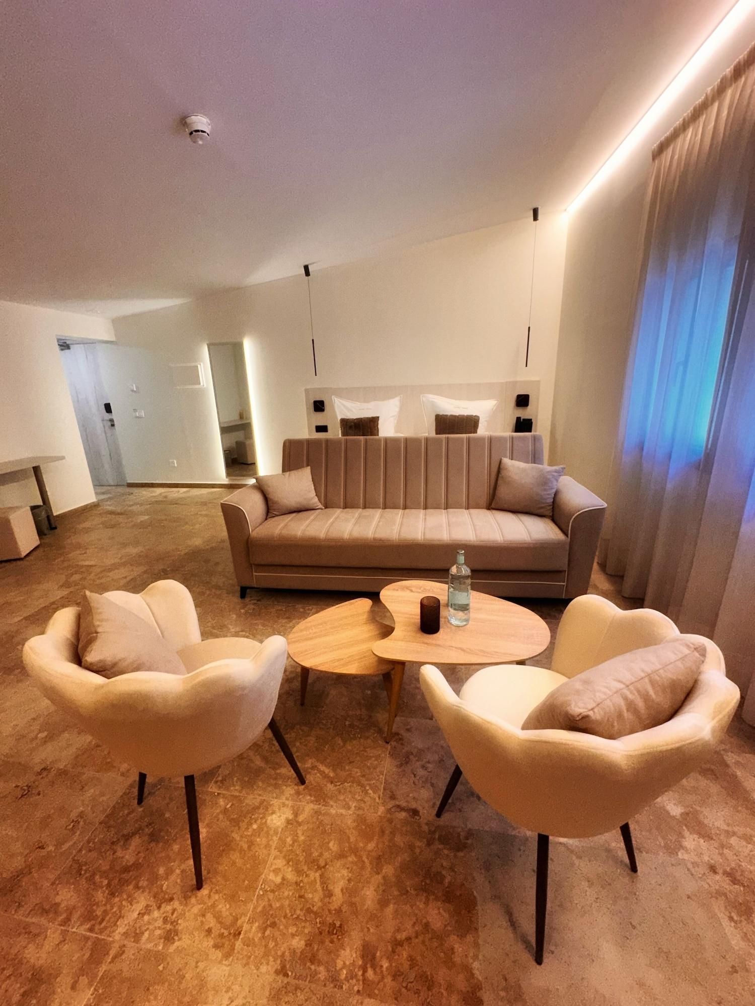 Una sala de estar moderna con un sofá, dos sillones y una mesa de centro.