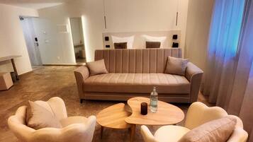Una sala de estar moderna con un sofá, dos sillones y una mesa de centro.