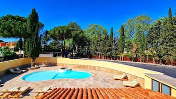 A pool area with lounge chairs and a circular pool.