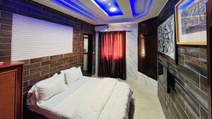 A hotel room with a bed, a window with blinds, a wall-mounted air conditioner, and a ceiling with blue lighting. - Hotel Darou Khoudoss (Dakar)