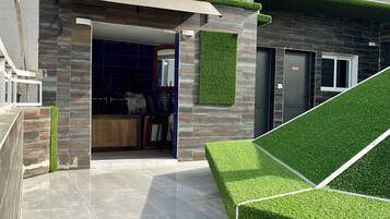 A modern house with a garage, a covered patio, and a green lawn.