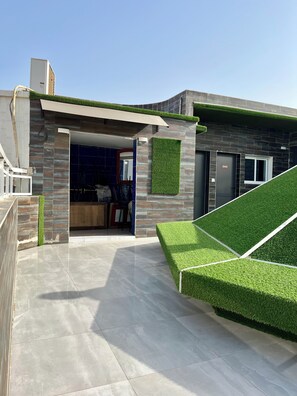 A modern house with a garage, a covered patio, and a green lawn. - Hotel Darou Khoudoss (Dakar)