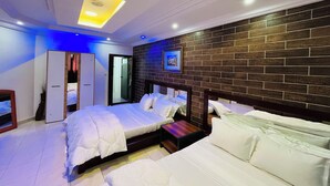 A modern bedroom with a large bed, a bedside table, a wardrobe, and a mirror. - Hotel Darou Khoudoss (Dakar)