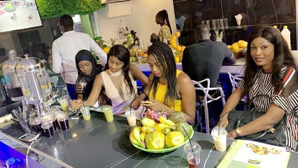A bar area with a counter, beverages, and a bowl of fruit. - Hotel Darou Khoudoss (Dakar)