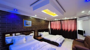 A hotel room with two beds, a flat-screen TV, a sofa, and a large window with curtains. - Hotel Darou Khoudoss (Dakar)