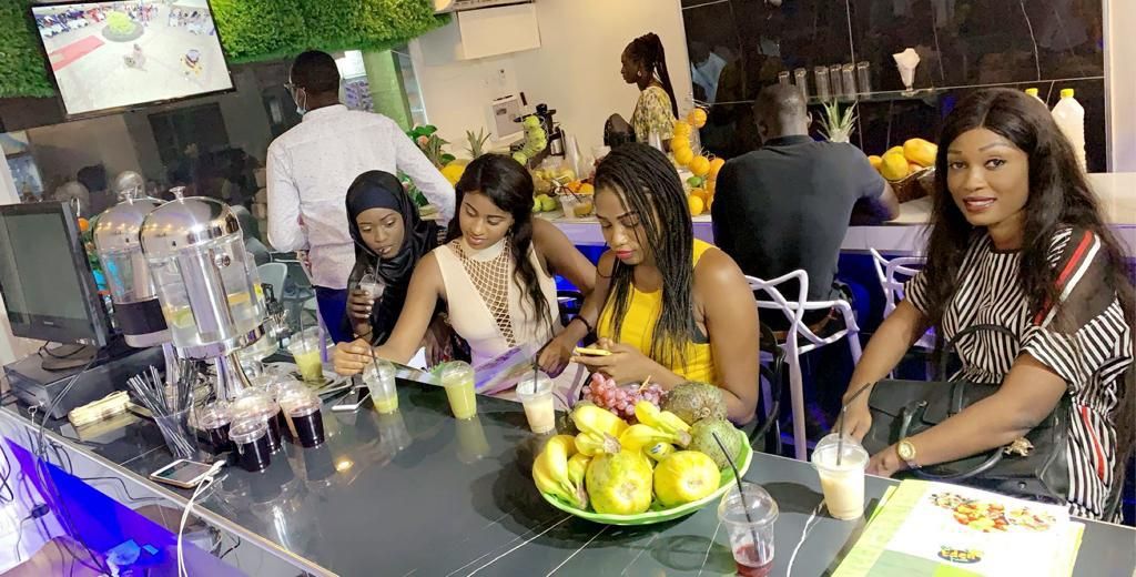 Un espace bar avec un comptoir, des boissons et un saladier rempli de fruits.