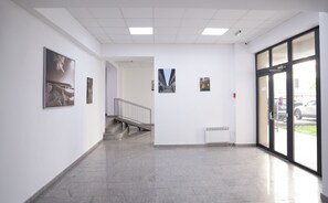 A hallway with a staircase, a radiator, and framed artwork on the walls. - Vitan Central Oasis Bucharest (Bucharest)