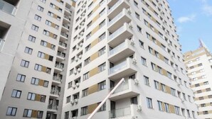 A multi-story residential building with balconies, a parking garage, and a clear sky. - Vitan Central Oasis Bucharest (Bucharest)