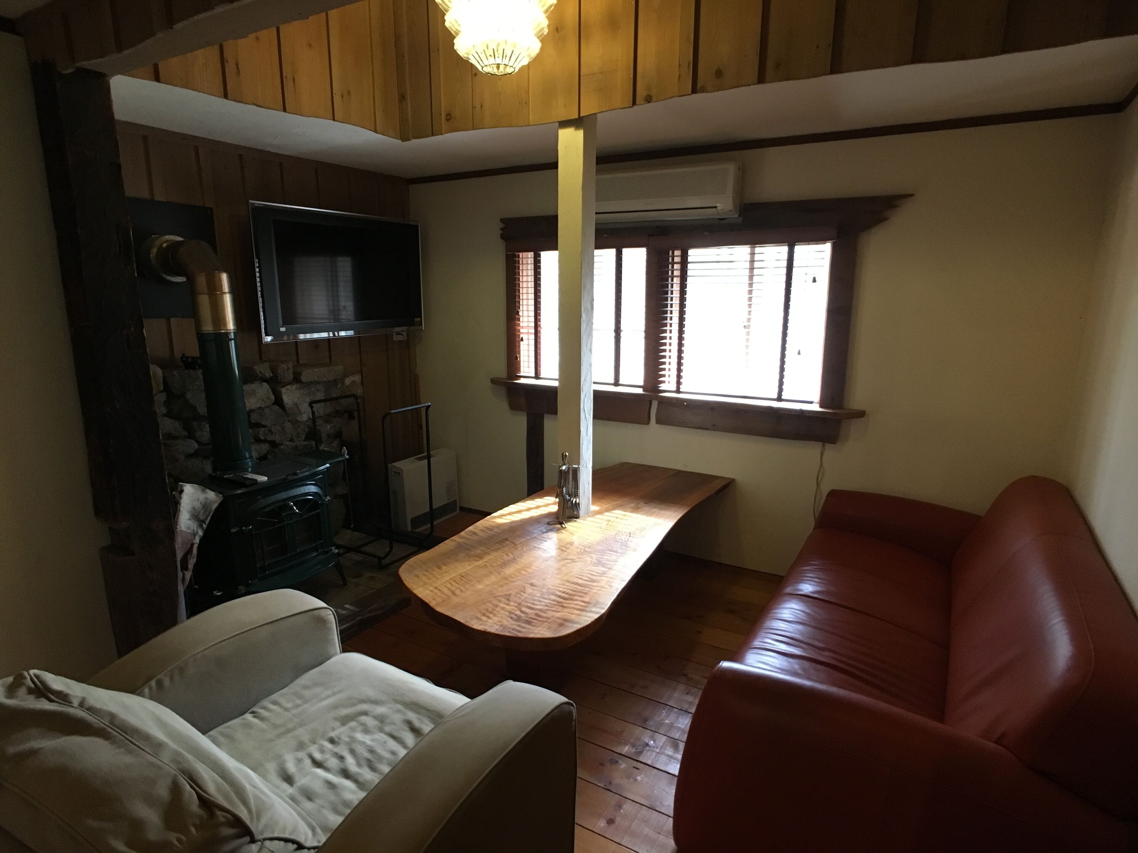 A cozy room with a fireplace, a sofa, a dining table, and a television.
