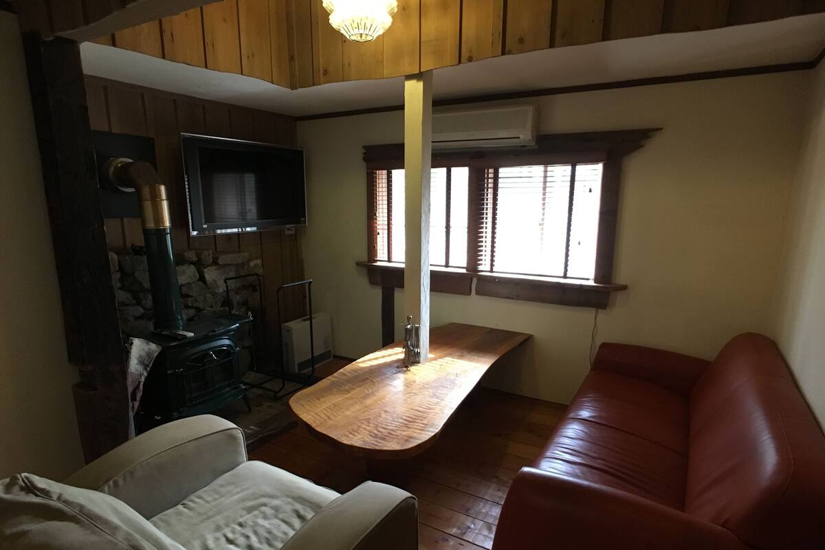 A cozy room with a fireplace, a sofa, a dining table, and a television.