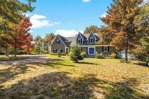 A two-story house with a front porch, a driveway, and a lawn.