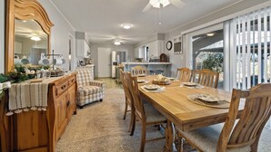 A dining area with a wooden table, chairs, and a large mirror.